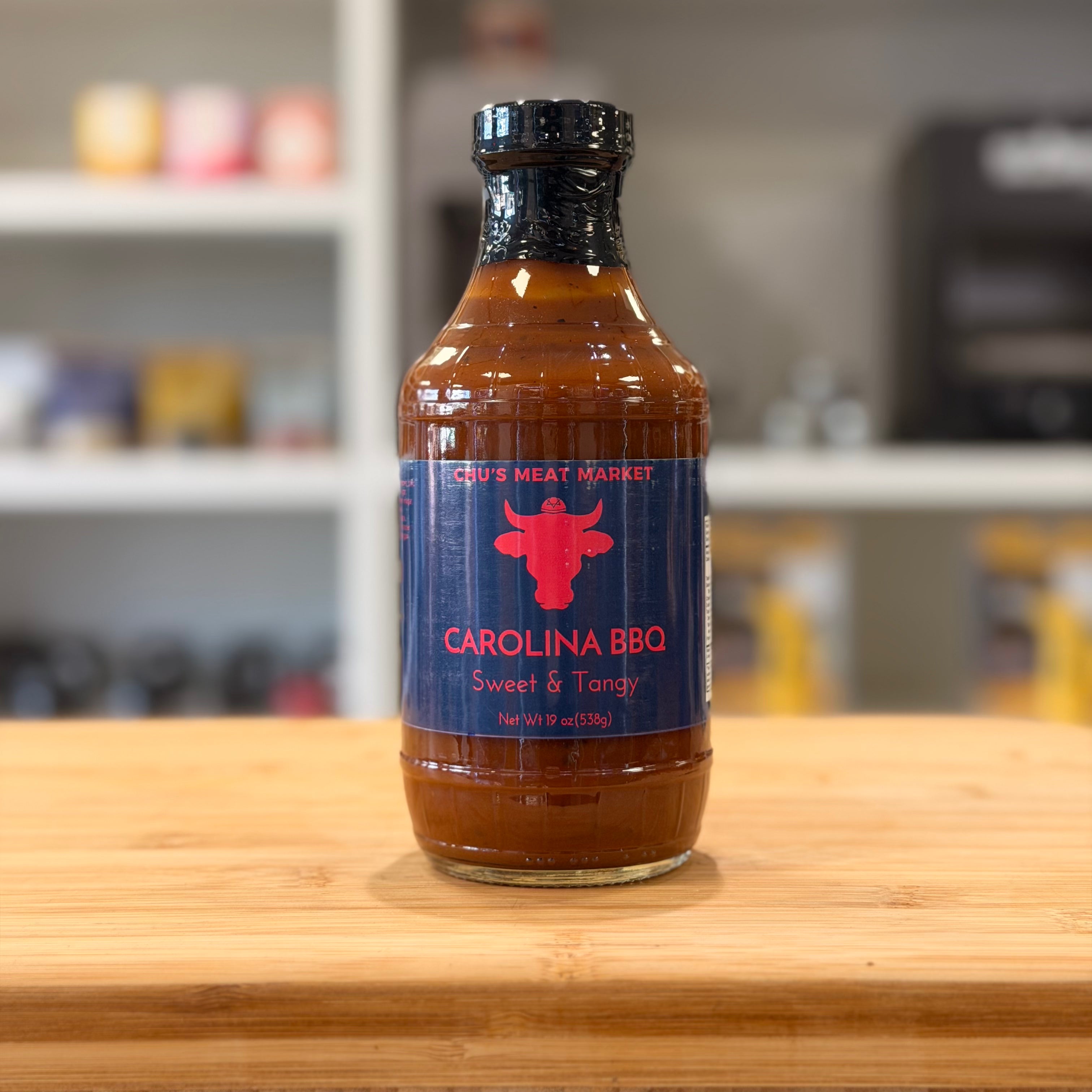 Bottle of Carolina BBQ sauce on a wooden surface with a blurred background