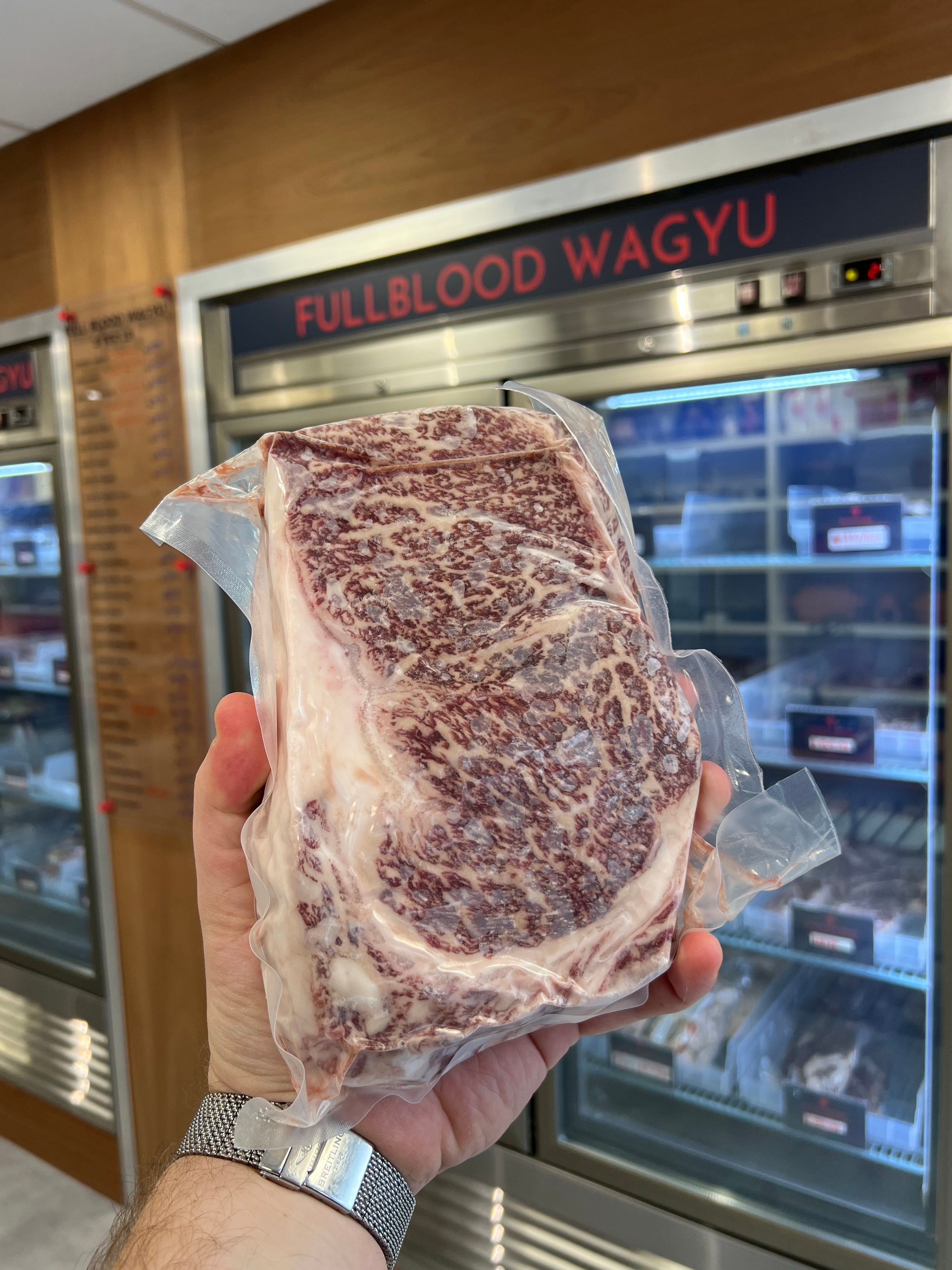 Holding a kosher wagyu ribeye steak in Chu's meat Market.
