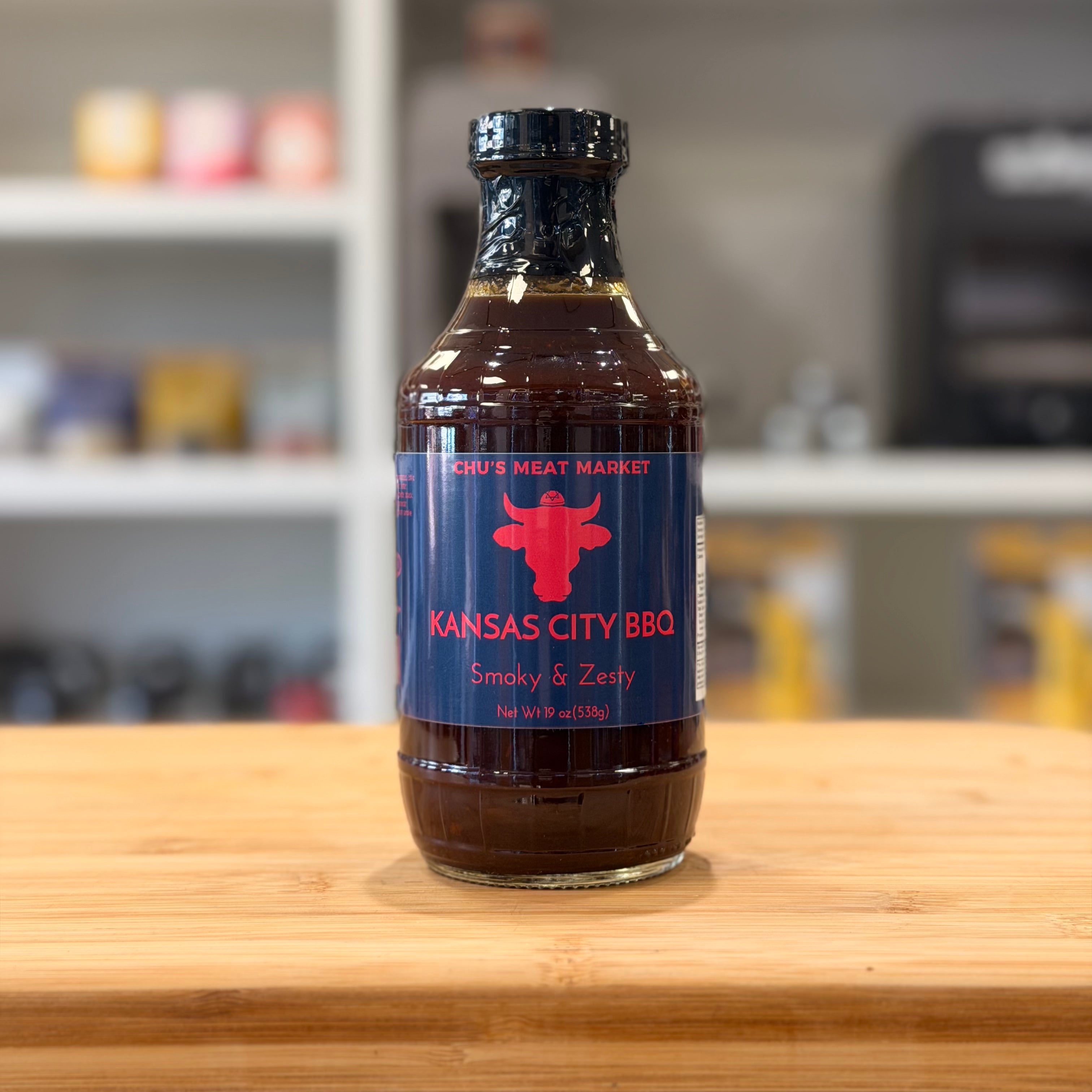 Bottle of Kansas City BBQ sauce on a wooden surface with a blurred background