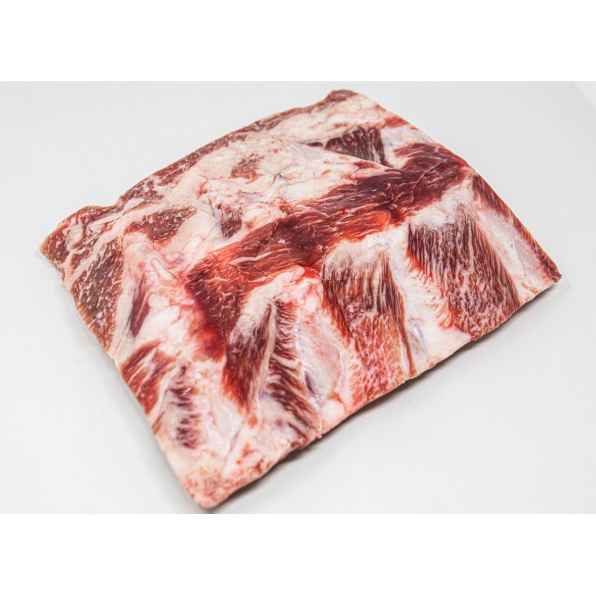 Kosher Fullblood American Wagyu back ribs displayed on a sleek marble countertop.