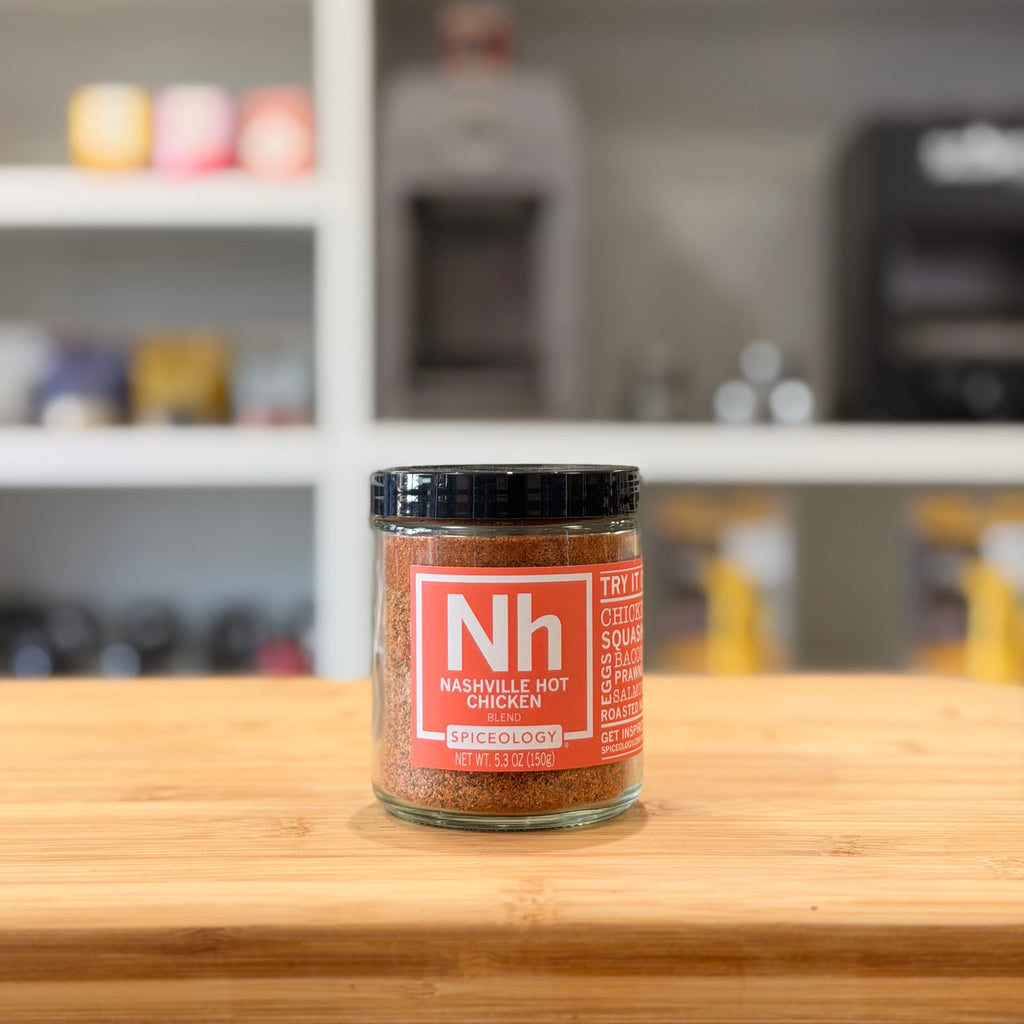 Spice jar with red label on a wooden surface, blurred kitchen background
