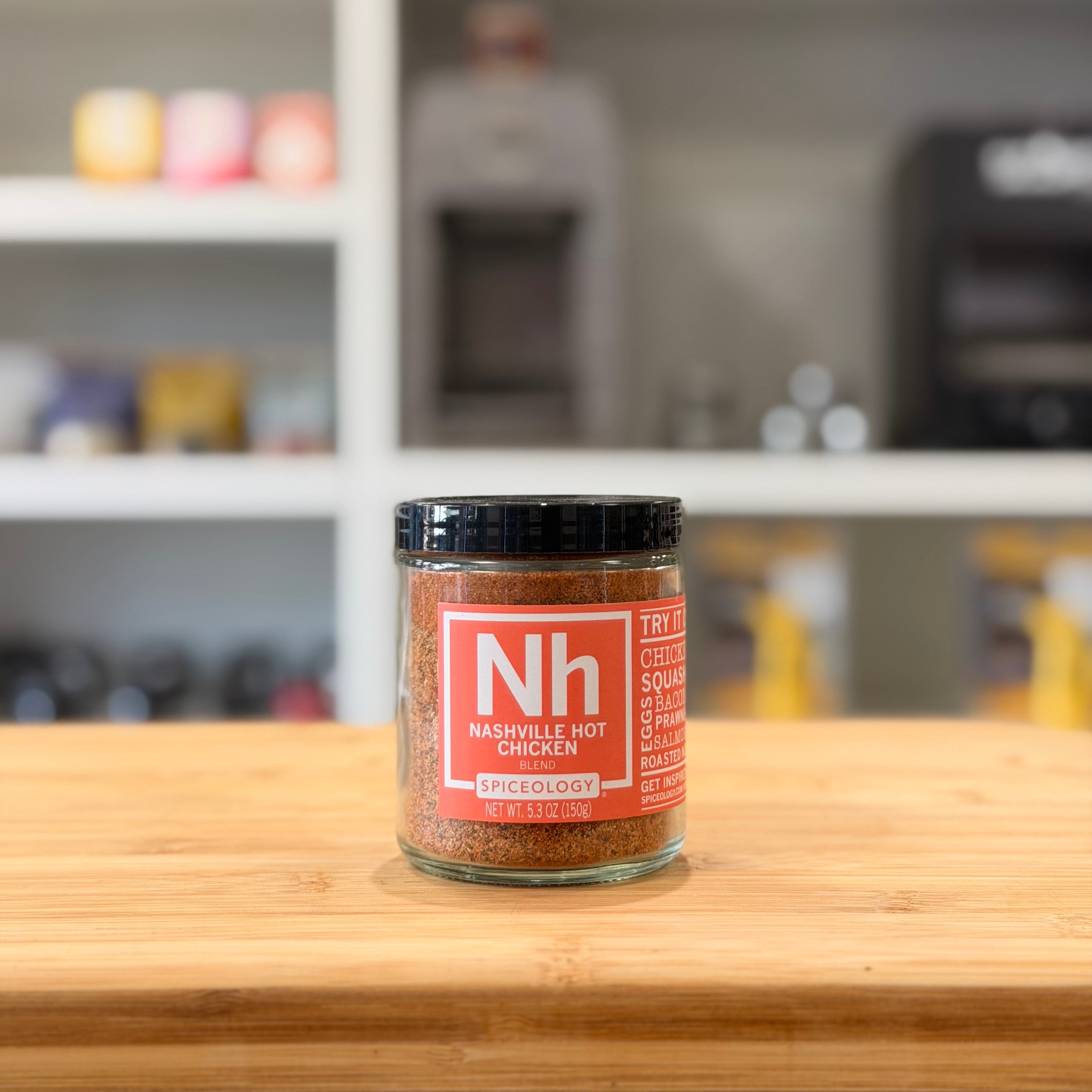 Spice jar with red label on a wooden surface, blurred kitchen background