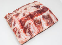 Kosher Fullblood American Wagyu back ribs displayed on a sleek marble countertop.
