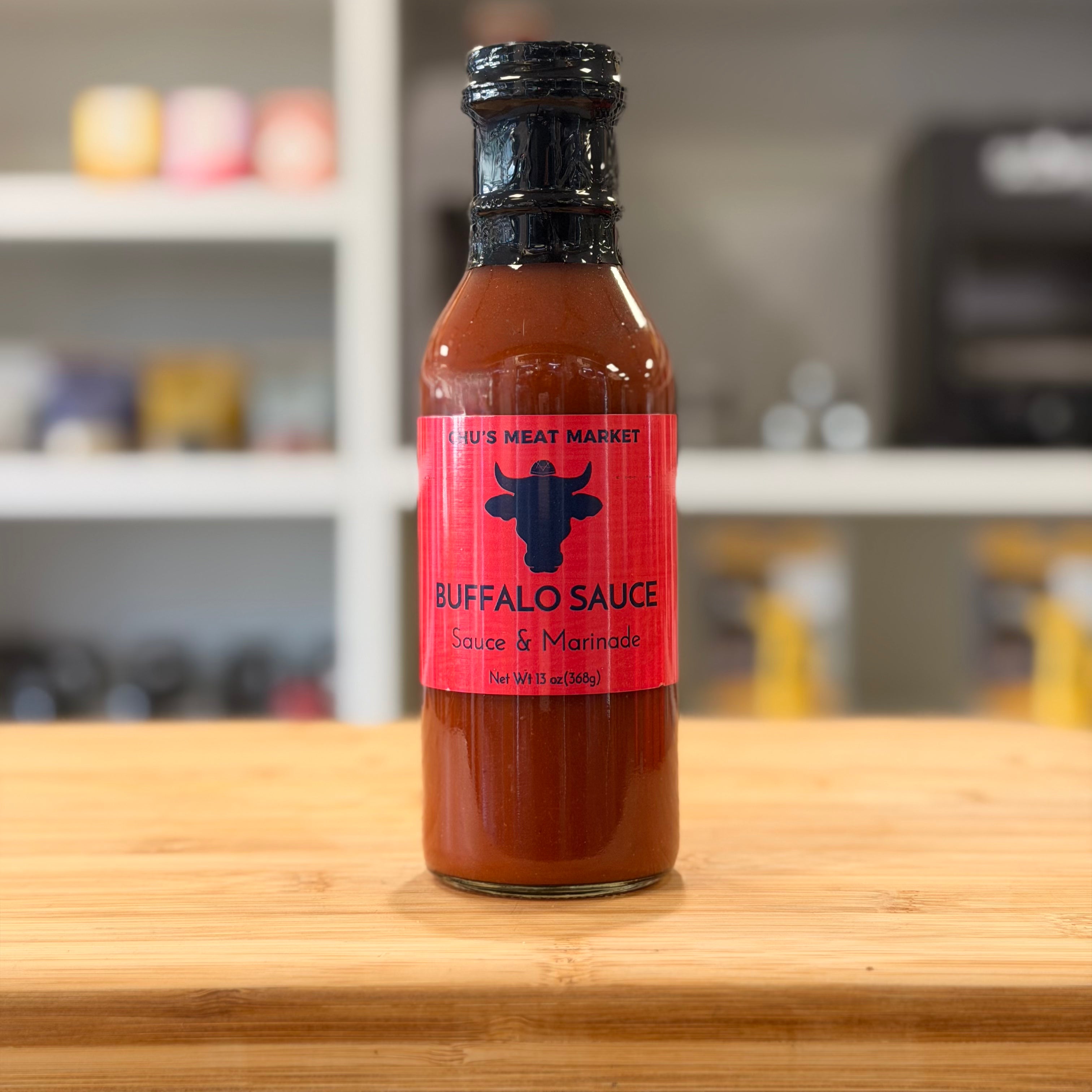 Bottle of buffalo sauce on a wooden surface with a blurred background