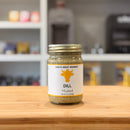 Jar of dill mustard from Chu's Meat Market on a wooden surface with a blurred background