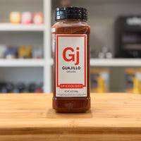 Spiceology Guajillo spice jar on a wooden surface with a blurred kitchen background