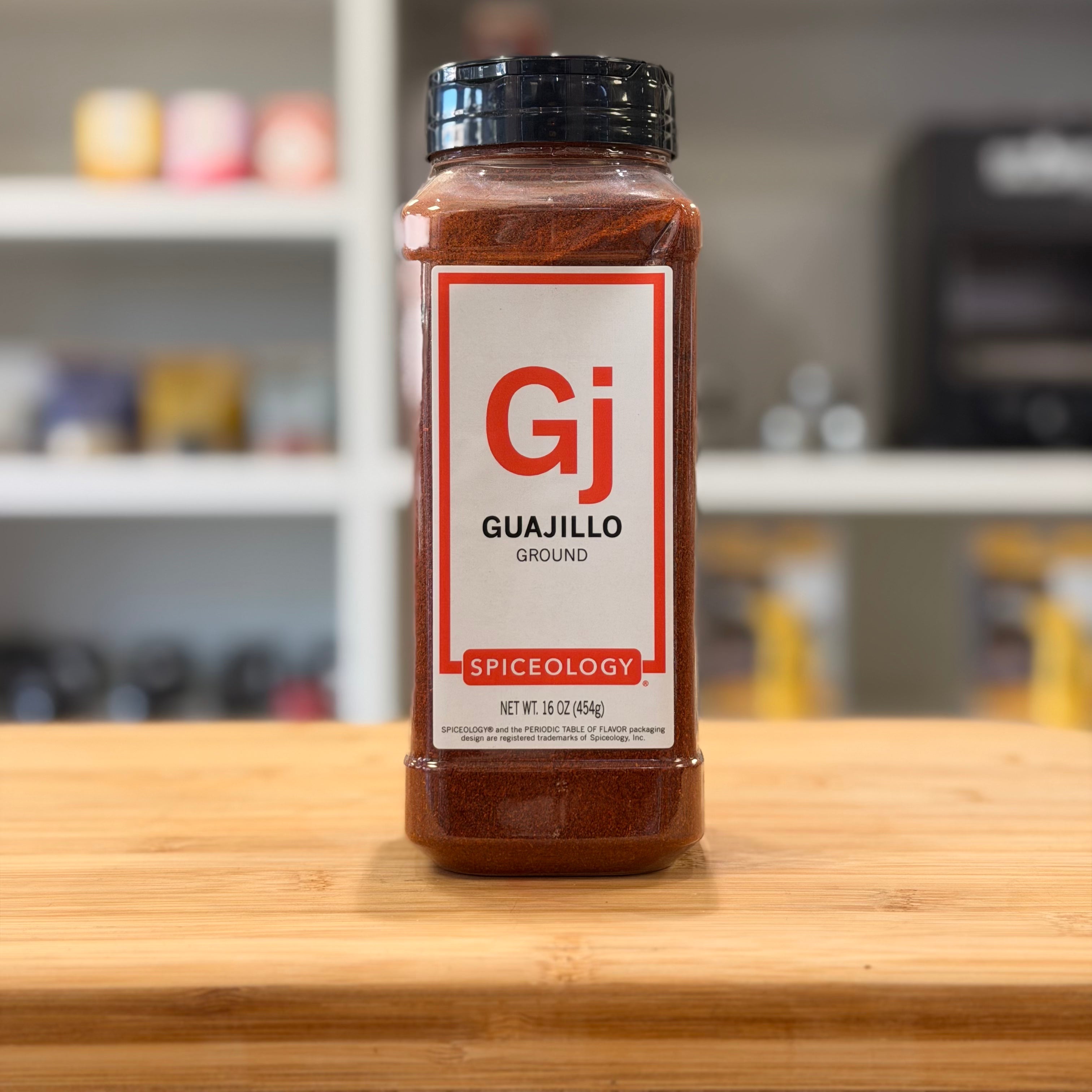 Spiceology Guajillo spice jar on a wooden surface with a blurred kitchen background