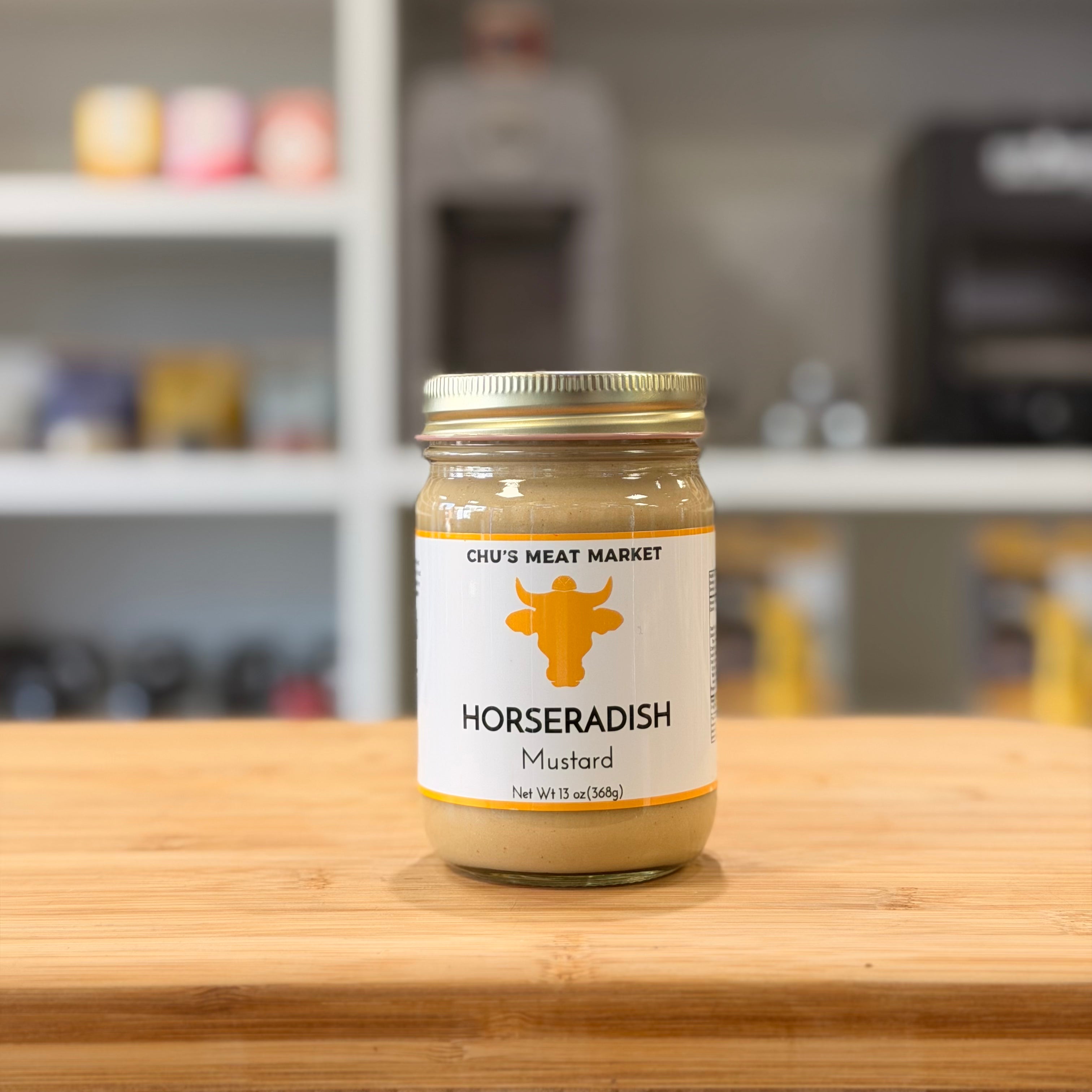 Jar of horseradish mustard on a wooden surface with a blurred background