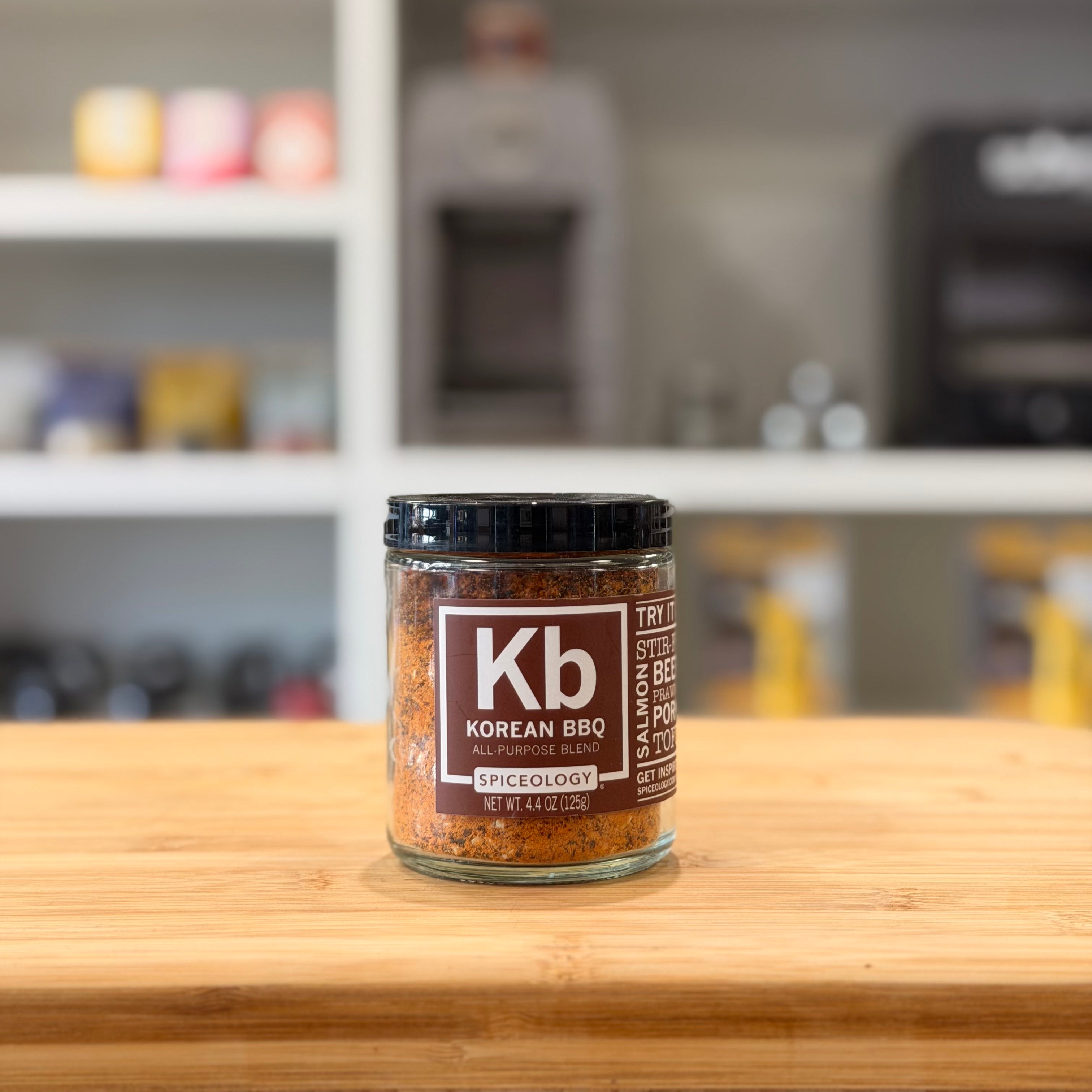 Jar of Korean BBQ spice mix on a wooden surface with a blurred kitchen background