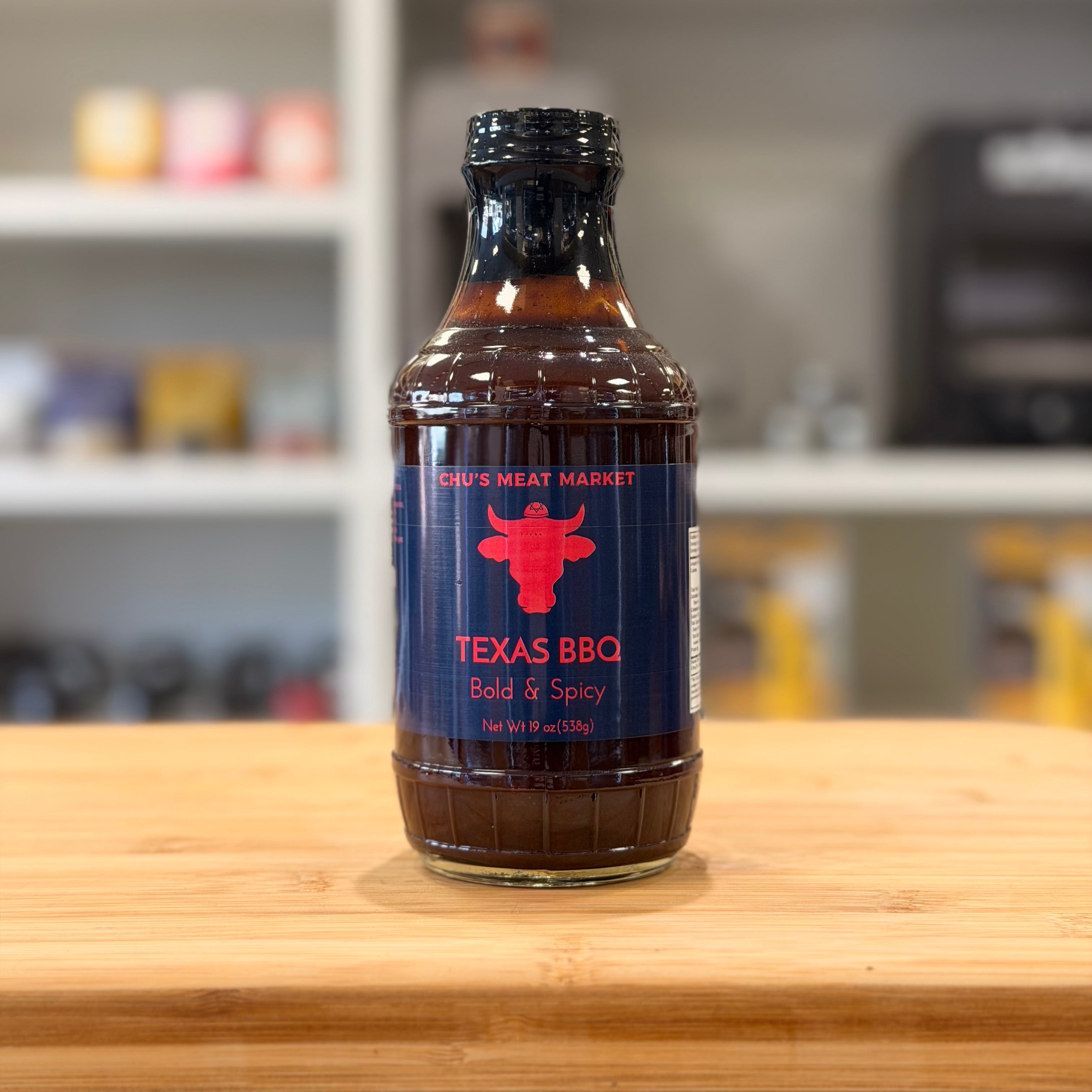 Bottle of Texas BBQ sauce on a wooden surface with a blurred background