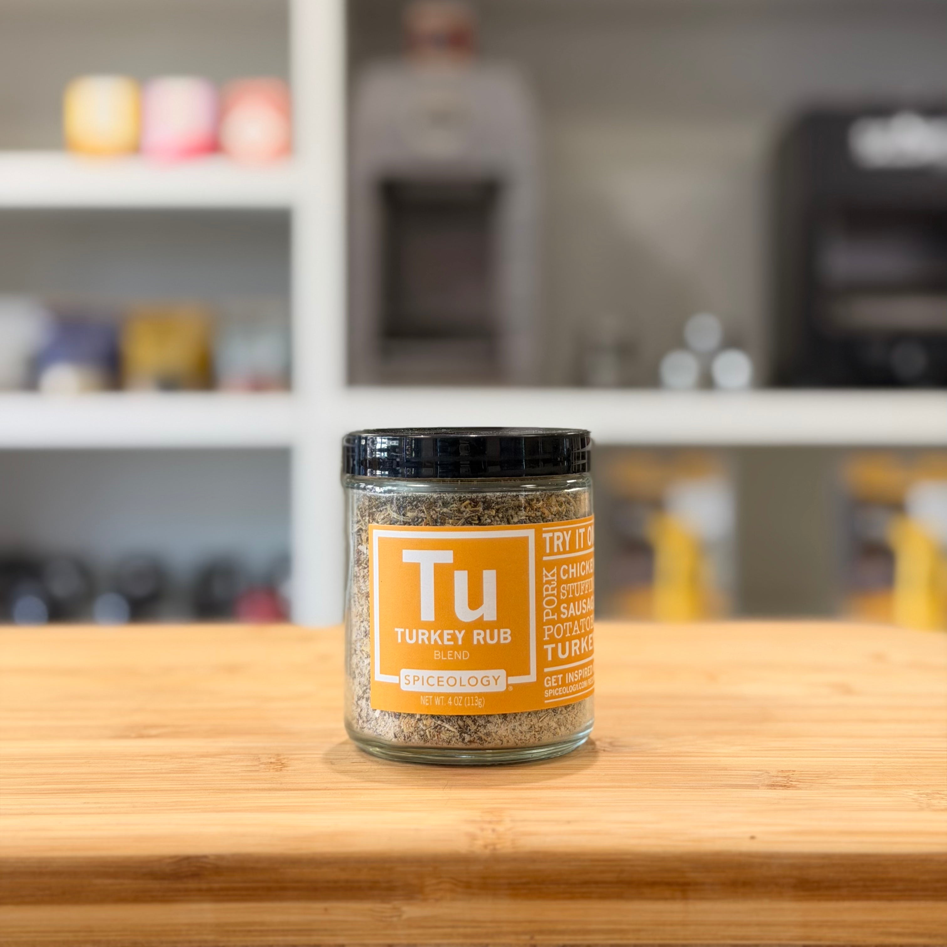 Jar of Tu Turkey Rub on a wooden surface with a blurred kitchen background